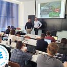 Two people of DB Cargo Czechia in front of a group of students from VSE.