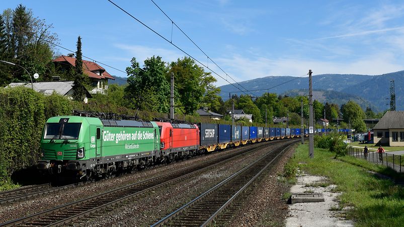 cargo train in front of mountains